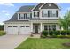 Two-story home with a three-car garage, a cozy covered porch, and manicured landscaping at 6804 Arlington Oaks Trl, Raleigh, NC 27603