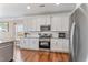 Bright kitchen with white cabinets, stainless steel appliances, granite counters, and hardwood floors at 6804 Arlington Oaks Trl, Raleigh, NC 27603