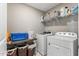 Functional laundry room with washer, dryer, shelving, and ample storage space at 6804 Arlington Oaks Trl, Raleigh, NC 27603