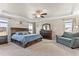 Spacious main bedroom with wood accent wall, sitting area, carpet, ceiling fan, and plenty of natural light at 6804 Arlington Oaks Trl, Raleigh, NC 27603