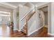 Traditional staircase with carpeted steps and wooden banister in a neutral-toned entryway at 6804 Arlington Oaks Trl, Raleigh, NC 27603