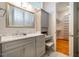 Bathroom with granite counters, gray cabinets, vanity area, marble tile, and access to the closet at 708 Kenmore Rd, Chapel Hill, NC 27514