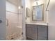 Bathroom with tiled glass shower, gray vanity with marble counters and a framed mirror at 708 Kenmore Rd, Chapel Hill, NC 27514