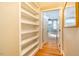 Hallway with hardwood floors, built-in shelves and an open door to a gray bedroom with ceiling fan at 708 Kenmore Rd, Chapel Hill, NC 27514