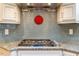 Close-up of a gas stovetop with granite counters and a blue tiled backsplash at 708 Kenmore Rd, Chapel Hill, NC 27514