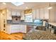 Kitchen features granite counters, stainless appliances, tiled backsplash, and beautiful wood floors at 708 Kenmore Rd, Chapel Hill, NC 27514