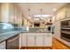 View of the bright kitchen and open living room with fireplace and custom built-ins at 708 Kenmore Rd, Chapel Hill, NC 27514