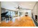 Spacious living room with hardwood floors, brick fireplace, large windows, and ceiling fan at 708 Kenmore Rd, Chapel Hill, NC 27514