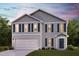 Charming two-story home with a welcoming front porch, attached two-car garage, and manicured lawn at 7576 Tanager Dr, Snow Camp, NC 27349
