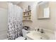 Cozy bathroom with decorative shower curtain, mirrored medicine cabinet, and storage shelves at 7925 Brown Bark Pl, Raleigh, NC 27615