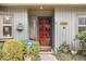 Inviting front entrance with a solid wood door, decorative features, and manicured shrubbery at 7925 Brown Bark Pl, Raleigh, NC 27615