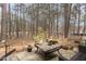 Landscaped outdoor patio with wrought iron furniture and wooded view at 7925 Brown Bark Pl, Raleigh, NC 27615