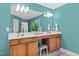 Bathroom with blue walls and a vanity with double sinks, accented by a decorative plant and neutral-colored tile at 80 Ingle View Ct, Burlington, NC 27215