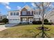 Charming two-story home features a well-manicured lawn, red shutters and a two-car garage at 80 Ingle View Ct, Burlington, NC 27215