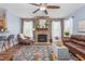Comfortable living room featuring a stone fireplace, large windows, and ceiling fan at 80 Ingle View Ct, Burlington, NC 27215