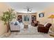 Comfortable living room with a ceiling fan, a neutral-colored couch, leather chairs, bookshelves, and bright natural light at 80 Ingle View Ct, Burlington, NC 27215