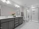 Well-lit bathroom with double sinks, quartz countertops, tiled floors, and walk-in shower at 978 Gateway Commons Cir, Wake Forest, NC 27587