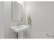 Elegant powder room features a pedestal sink, decorative mirror, and neutral decor at 978 Gateway Commons Cir, Wake Forest, NC 27587