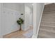 Hallway featuring wood floors, a staircase, and a decorative plant, creating a welcoming space at 978 Gateway Commons Cir, Wake Forest, NC 27587