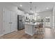 Contemporary kitchen with stainless steel refrigerator, island seating, and modern lighting at 978 Gateway Commons Cir, Wake Forest, NC 27587
