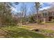 Scenic backyard view with bridge over creek, mature trees, and partial view of brick home at 105 Wicklow Pl, Chapel Hill, NC 27517