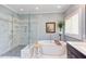 Modern bathroom featuring a soaking tub, glass shower and marble tiling at 105 Wicklow Pl, Chapel Hill, NC 27517