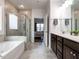Bright bathroom featuring a soaking tub, a glass enclosed shower, and a double sink vanity at 106 Ivory Ln, Raleigh, NC 27610