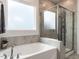 Modern bathroom featuring a soaking tub, glass-enclosed shower, and tiled walls for a spa-like experience at 106 Ivory Ln, Raleigh, NC 27610