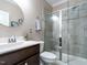 Bathroom featuring a tiled glass shower, a round mirror, and a dark wood vanity at 106 Ivory Ln, Raleigh, NC 27610