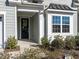Close-up of a charming front entrance, featuring a black front door with a decorative wreath and sidelight window at 106 Ivory Ln, Raleigh, NC 27610