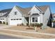 View of a single Gathering home with neutral siding, a black roof, white two-car garage and well-kept yard at 106 Ivory Ln, Raleigh, NC 27610