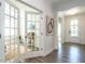 Bright hallway featuring hardwood floors, white trim, and a glimpse into a sunlit office space at 106 Ivory Ln, Raleigh, NC 27610
