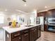 Modern kitchen island featuring a quartz countertop, stainless steel appliances, and dark brown cabinetry at 106 Ivory Ln, Raleigh, NC 27610