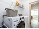 Functional laundry area with a washer, dryer, wire shelving and view to an adjacent living space at 106 Ivory Ln, Raleigh, NC 27610