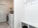 Well-organized laundry room with a washer, dryer, and a built-in bench and cubby storage at 106 Ivory Ln, Raleigh, NC 27610
