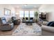 Cozy living room featuring comfortable seating, a patterned rug, and plenty of natural light from the windows at 106 Ivory Ln, Raleigh, NC 27610