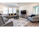 Inviting living room boasts modern furniture, a stylish area rug, and a large window for plenty of natural light at 106 Ivory Ln, Raleigh, NC 27610
