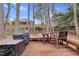 Backyard with wooden deck, grill, outdoor dining table and chairs, and trees in the background at 107 Fishers Creek Ct, Cary, NC 27513