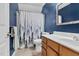 Bathroom with blue walls, a white forest-themed shower curtain, and a wooden vanity at 107 Fishers Creek Ct, Cary, NC 27513