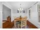 Bright dining area with hardwood floors, wainscoting, chandelier, and neutral decor at 107 Fishers Creek Ct, Cary, NC 27513