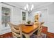 This is a dining room with a hardwood table, area rug, and windows showing greenery outside at 107 Fishers Creek Ct, Cary, NC 27513