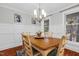 Traditional dining room featuring wainscoting, a wood table, chandelier, and lots of natural light at 107 Fishers Creek Ct, Cary, NC 27513
