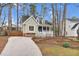 View of charming single Gathering home with a welcoming front porch and a long driveway, surrounded by tall trees at 107 Fishers Creek Ct, Cary, NC 27513
