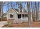Charming home featuring dormer windows, a cozy front porch, and a well-maintained yard with mature trees at 107 Fishers Creek Ct, Cary, NC 27513
