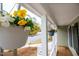 Close-up of hanging flower baskets on a charming front porch with wood floors and white pillars at 107 Fishers Creek Ct, Cary, NC 27513