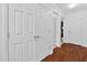 Hallway with hardwood floors, white doors, neutral walls, and access to multiple rooms at 107 Fishers Creek Ct, Cary, NC 27513