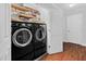 Well-organized laundry room with front loading washer and dryer and shelving above at 107 Fishers Creek Ct, Cary, NC 27513