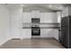 Bright kitchen boasts stainless steel appliances, white cabinets, and granite countertops at 108 Hybrid St, Oxford, NC 27565