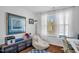 Sun-lit bedroom with a cozy beanbag chair and view to the yard through large window at 11 Marsh Landing Ct, Durham, NC 27703