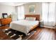 Neutral bedroom with wood-frame bed, hardwood floors, dresser, mirror, and natural light at 11 Marsh Landing Ct, Durham, NC 27703